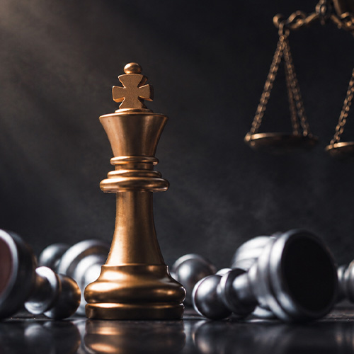 Golden chess king stands amid fallen pieces with justice scales, symbolizing legal strategy, leadership, and victory